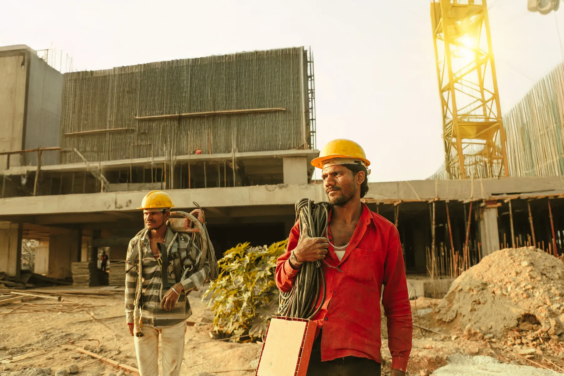 Indian construction workers wearing helmets at a building site